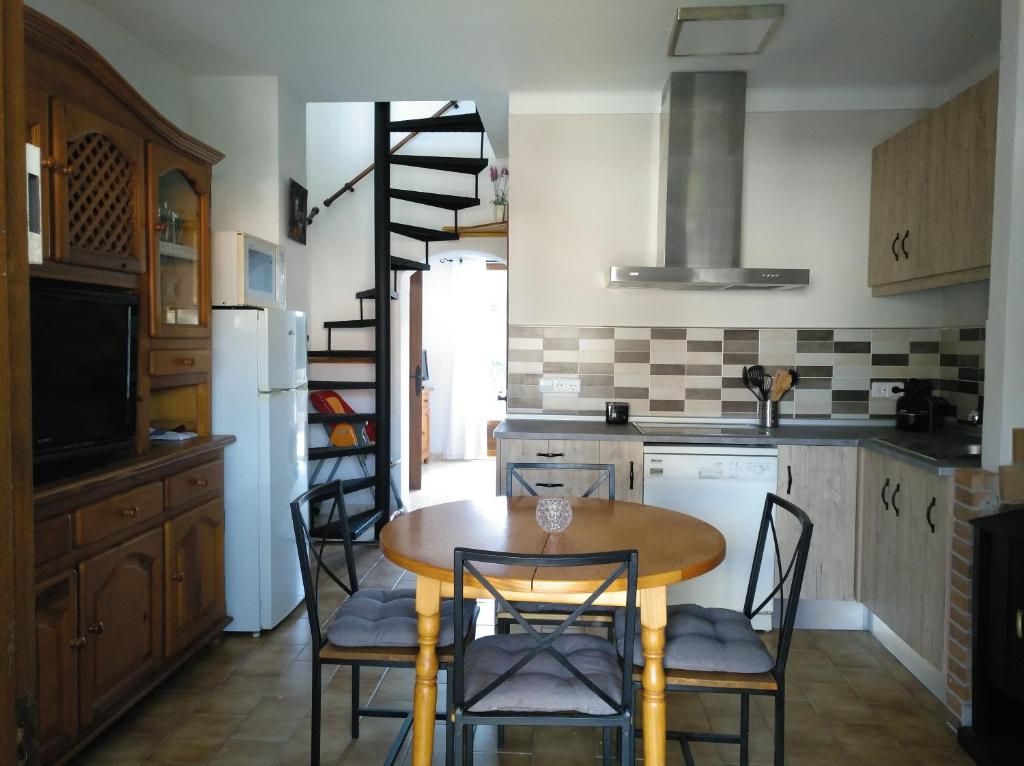 een keuken met een houten tafel en stoelen bij Casa katy in L'Escala