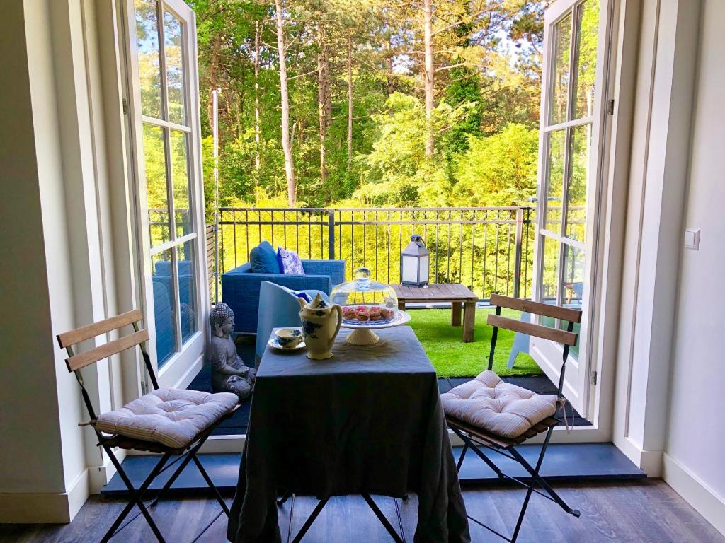 Habitación con porche con mesa y sillas. en Happy Bentveld Guesthouse en Bentveld