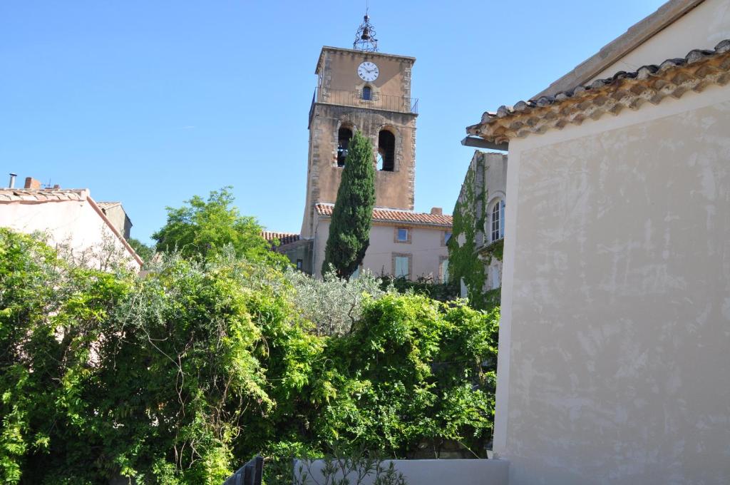 un edificio con una torre de reloj a lo lejos en La vigne appartement, en Sablet