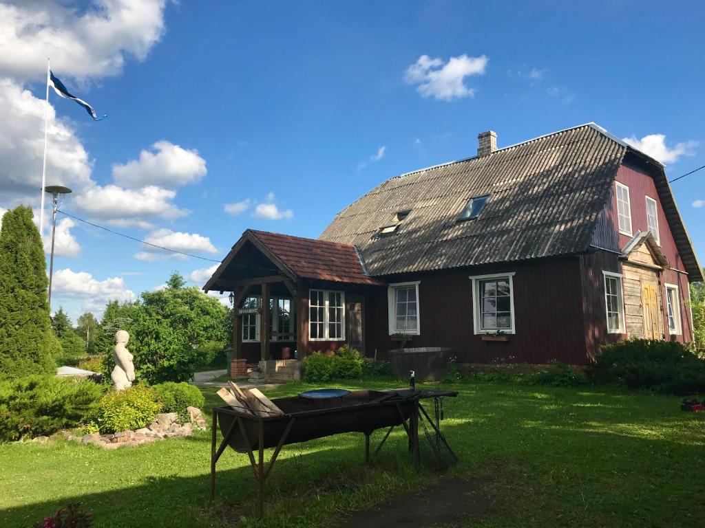 una casa con una parrilla delante de ella en Järve Talu Puhkemaja en Otepää
