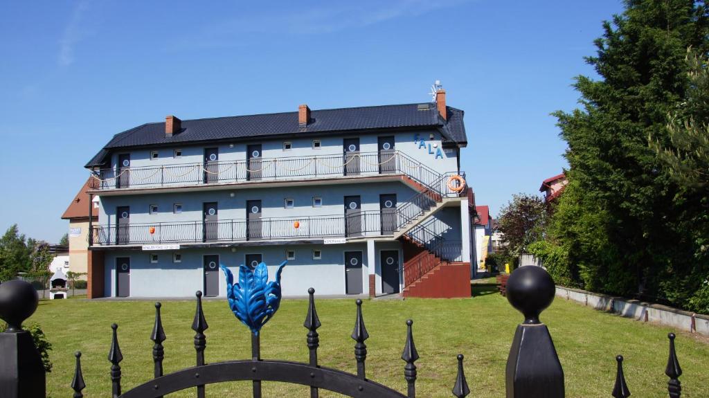 a building with a fence in front of it at Fala in Karwia