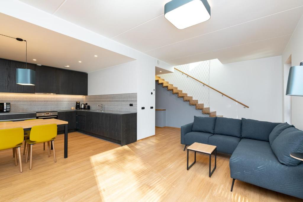 - un salon et une cuisine avec un canapé bleu et des fauteuils jaunes dans l'établissement Self-check-in 3 bedroom apartment with sauna and balconies, à Tallinn