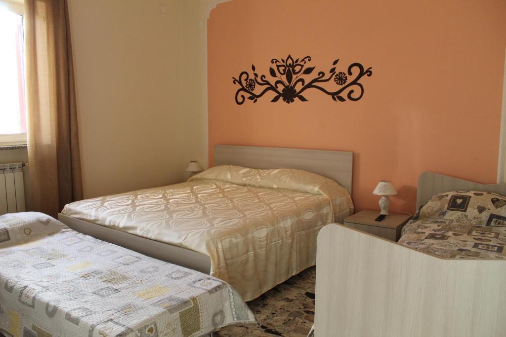 a bedroom with two beds and a chandelier on the wall at Green Garden in Pompei