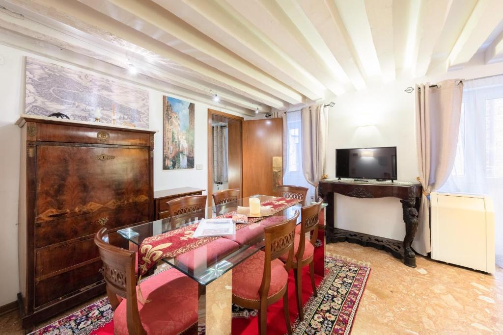 Ca' del Carro Family Apartment في البندقية: غرفة معيشة مع طاولة وتلفزيون