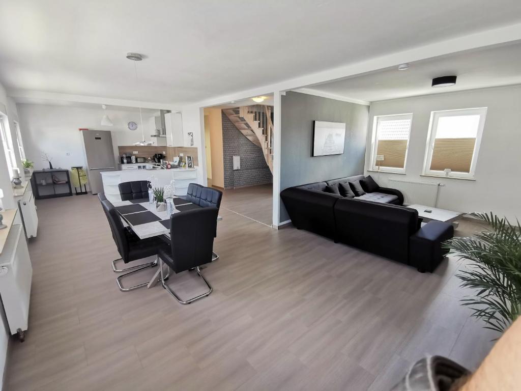 a living room with a black couch and a table at Ferienwohnung bei Schwarzkopf in Nordenham