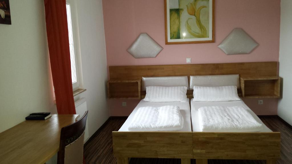 a bedroom with two beds and a desk and a table at Hotel La Terrazza in Wetzlar