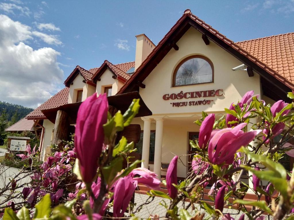 budynek z fioletowymi kwiatami przed nim w obiekcie Gościniec Pięciu Stawów w mieście Ustrzyki Dolne