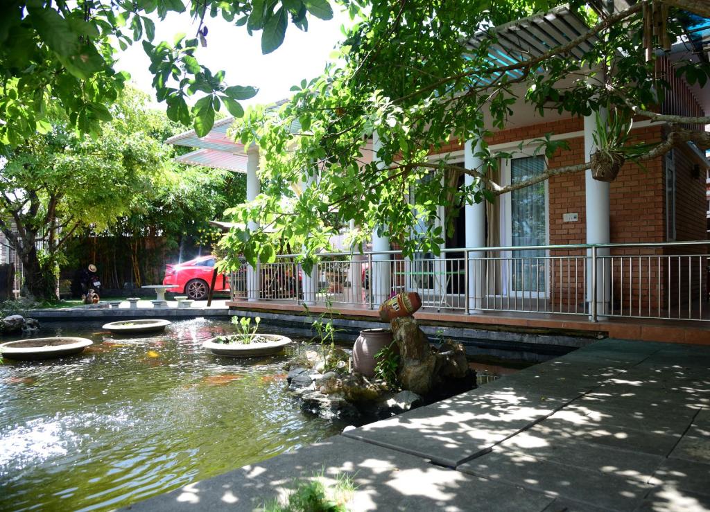 un estanque frente a una casa con un edificio en Hà Phương Homestay, en Lang Co