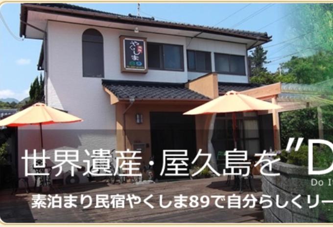 a house with an asian writing on the side of it at Yakushima Park Guesthouse in Yakushima