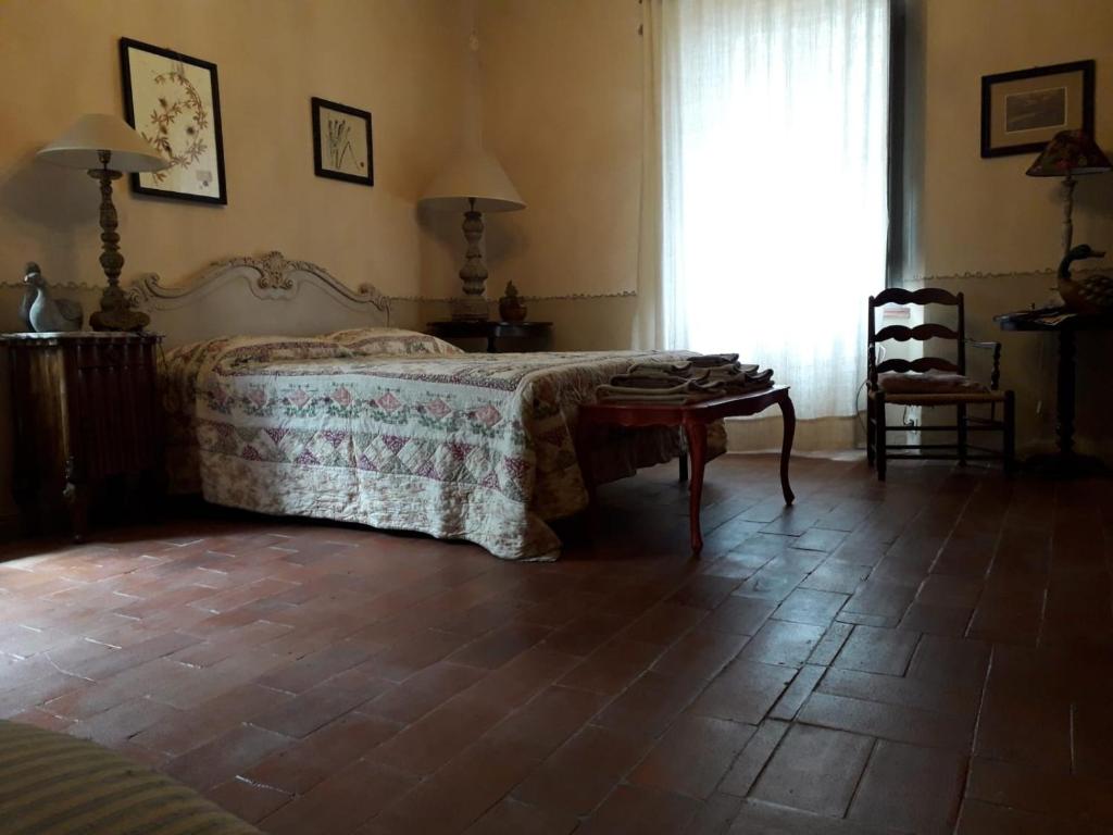 a bedroom with a bed and a table and a window at La Casa del Maestro in Monsummano Terme