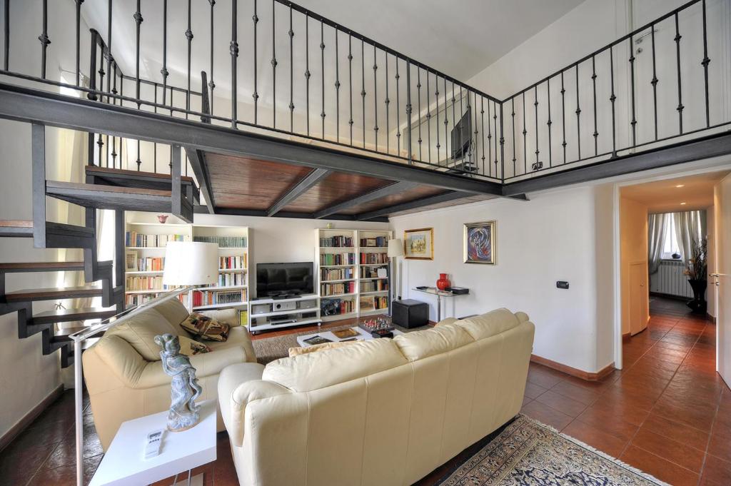 a living room with a couch and a staircase at ROME LUXURY HOUSE - THE SUITE in Rome