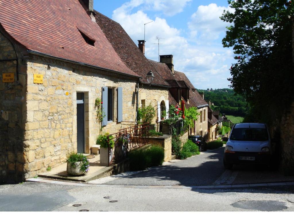 um carro estacionado em frente a uma fila de casas em Maison de la Combe em Domme