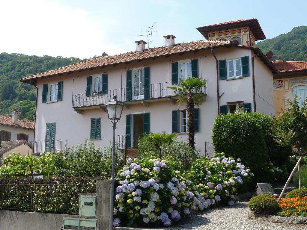 a house with a bunch of flowers in front of it at Forster's Nest in Cannero Riviera