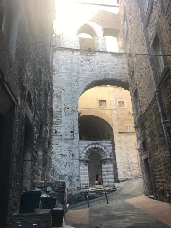 an archway in an old stone building with a bench at La casa di Benedetta in Perugia