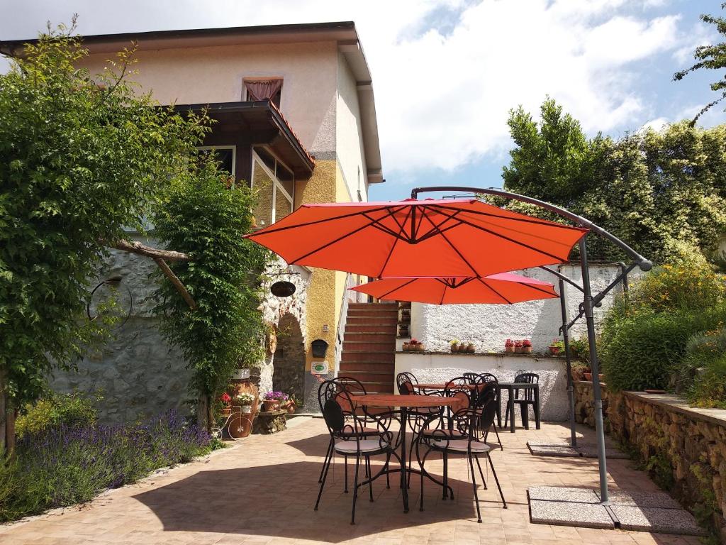 ベヴェリーノにあるCountry House La Scorticaのパティオ(赤い傘付きのテーブルと椅子付)