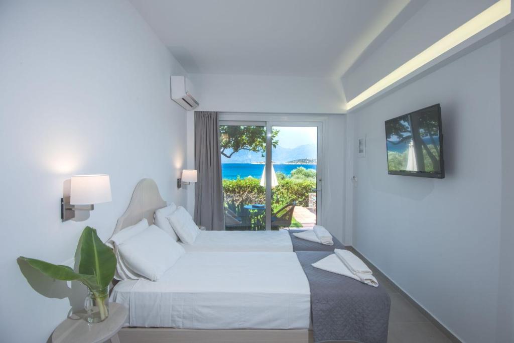 una camera da letto con un letto e vista sull'oceano di Mirabella Apartments ad Ágios Nikólaos