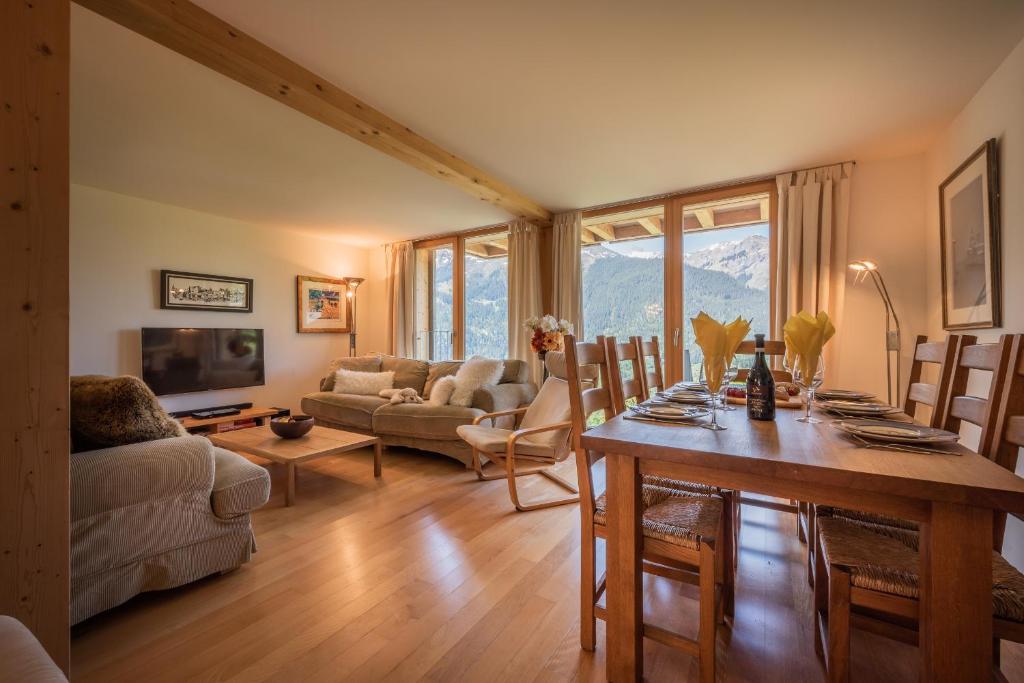 sala de estar con mesa y sofá en Chalet Roossi 2 en Wengen