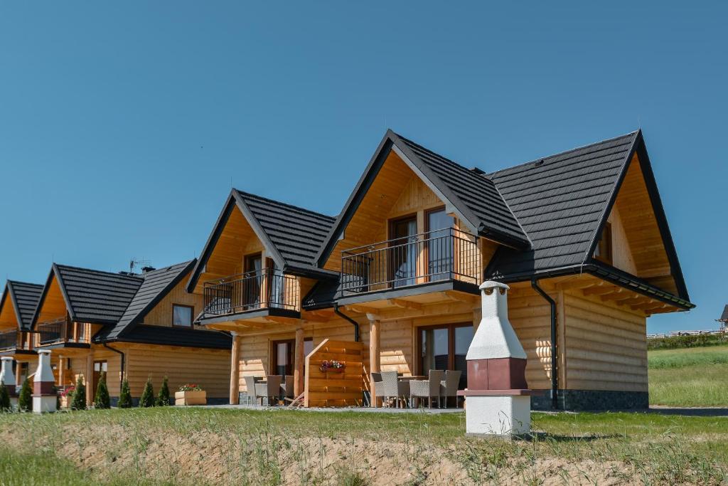 a log home with a black roof at Domki CHRYCA in Kluszkowce