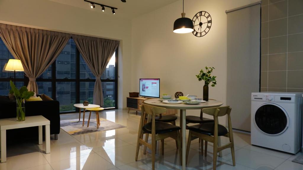 eine Küche und ein Wohnzimmer mit einem Tisch und Stühlen in der Unterkunft Orangerabbit@IconCity in Petaling Jaya
