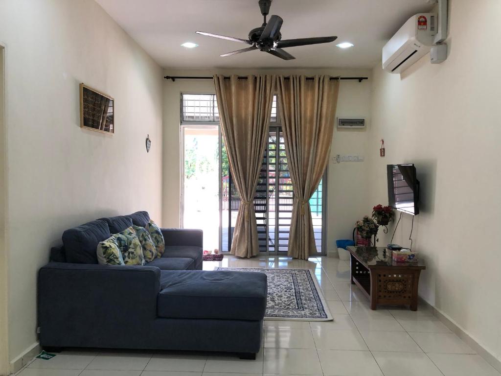 salon z niebieską kanapą i wentylatorem sufitowym w obiekcie Magnolia 1 Homestay w mieście Kuala Besut
