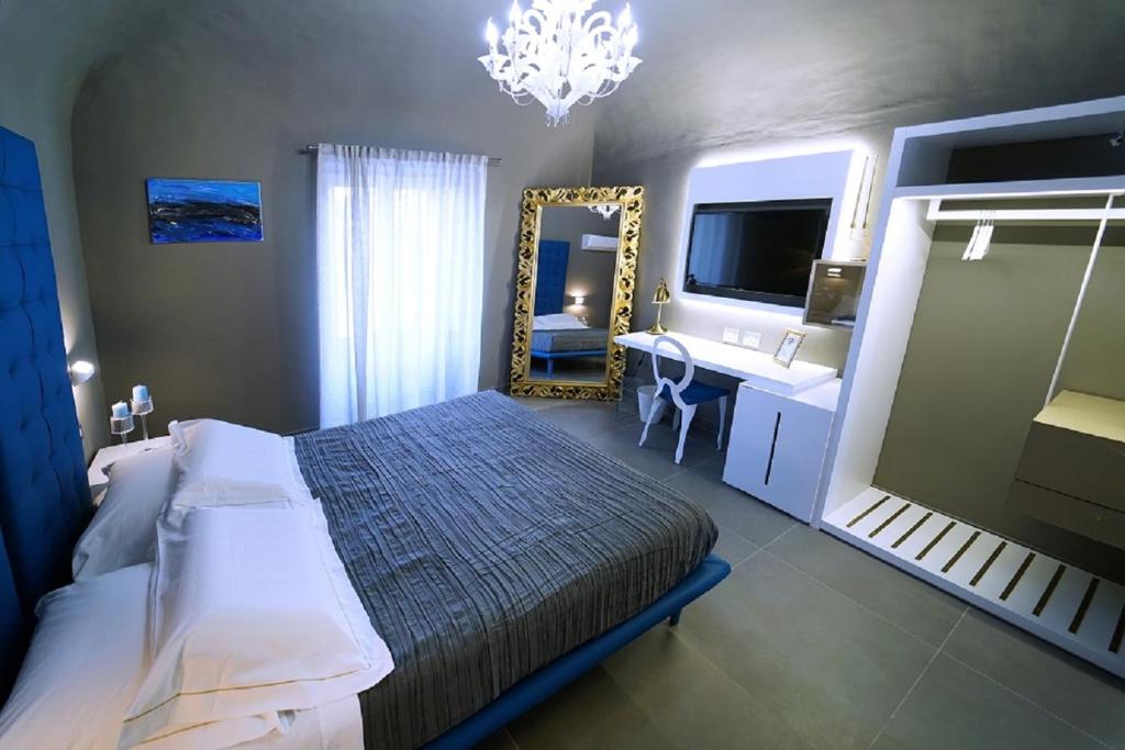 a bedroom with a bed and a mirror and a sink at Etna Suite Group in Catania