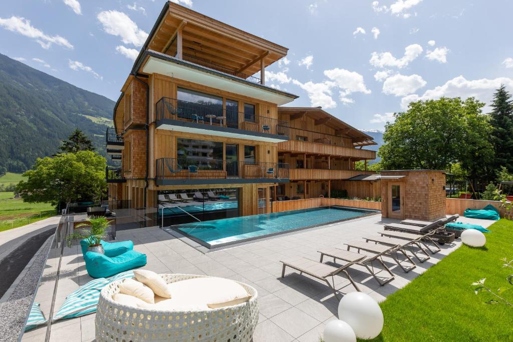 リート・イム・ツィラータールにあるAppartement Zillertal Klee mit Restaurant KleemenTineのスイミングプール付きのヴィラ、家