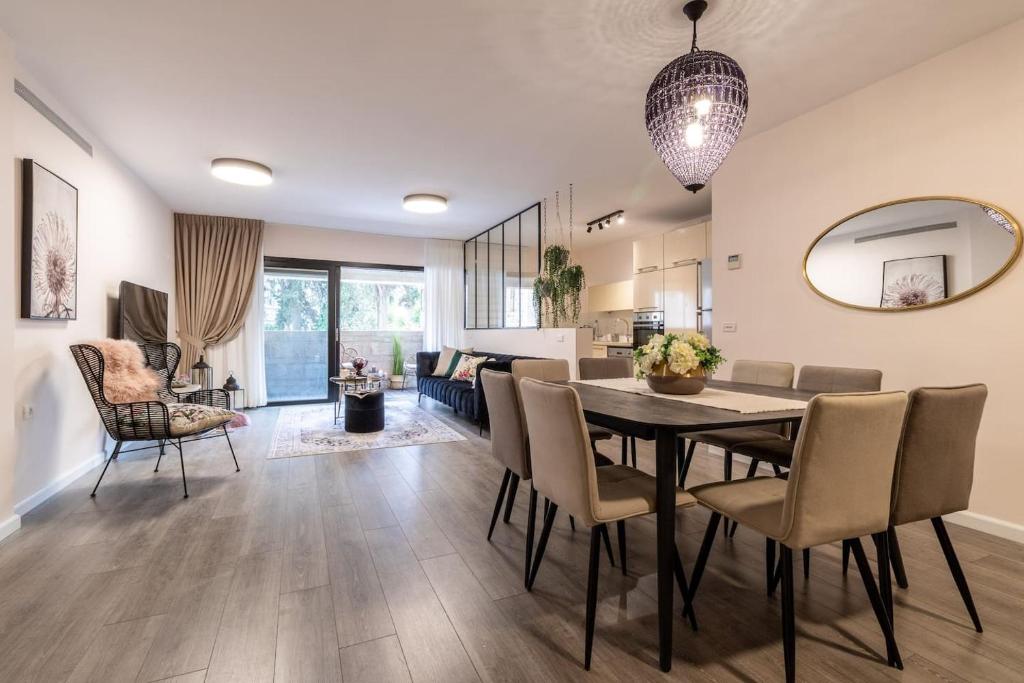 a dining room and living room with a table and chairs at King David Residence Luxury 4 BD/Pool/Gym/Parking in Jerusalem