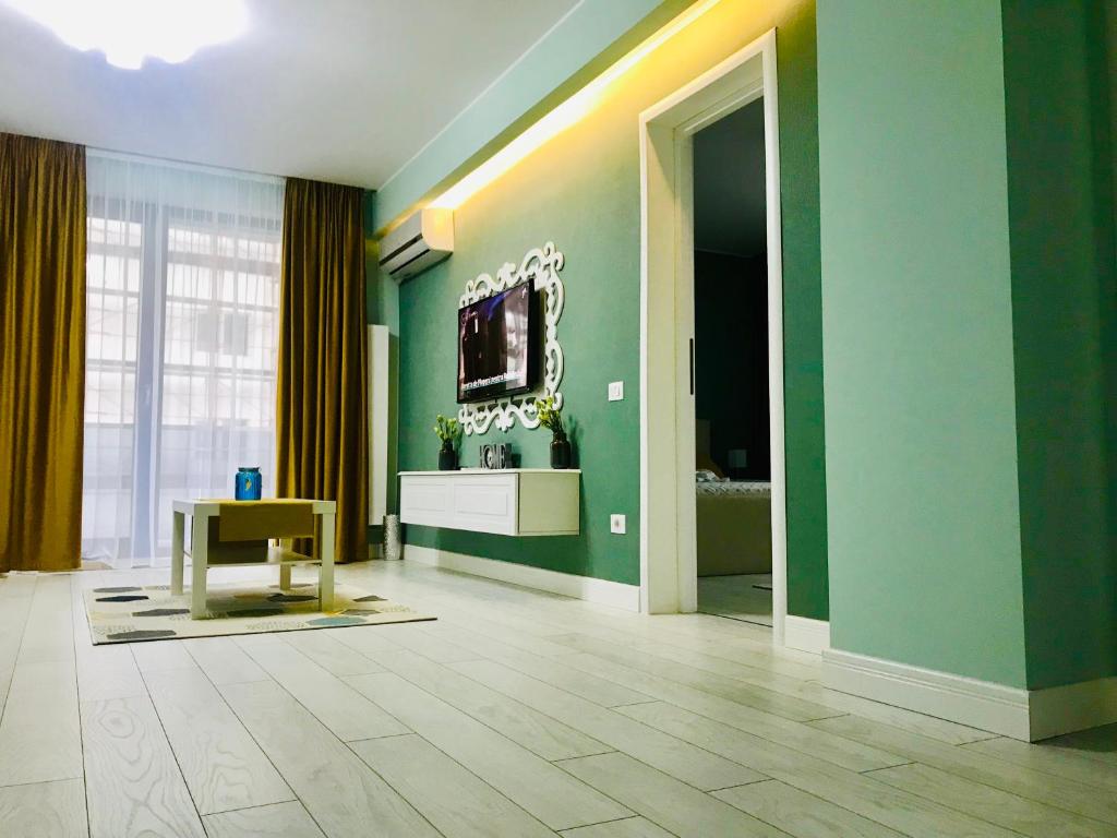 ein Wohnzimmer mit grünen Wänden und einem TV in der Unterkunft DarNiDa Luxury Apartment in Mamaia Nord – Năvodari