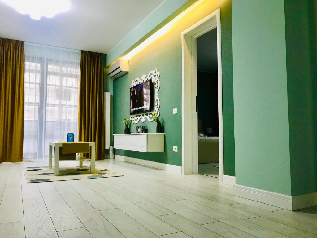a living room with green walls and a television at DarNiDa Luxury Apartment in Mamaia Sat/Năvodari