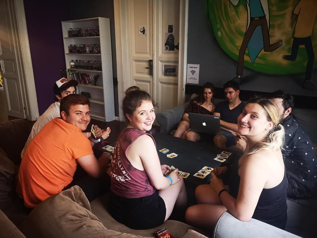 a group of people sitting on a couch playing cards at Vitae Hostel in Budapest