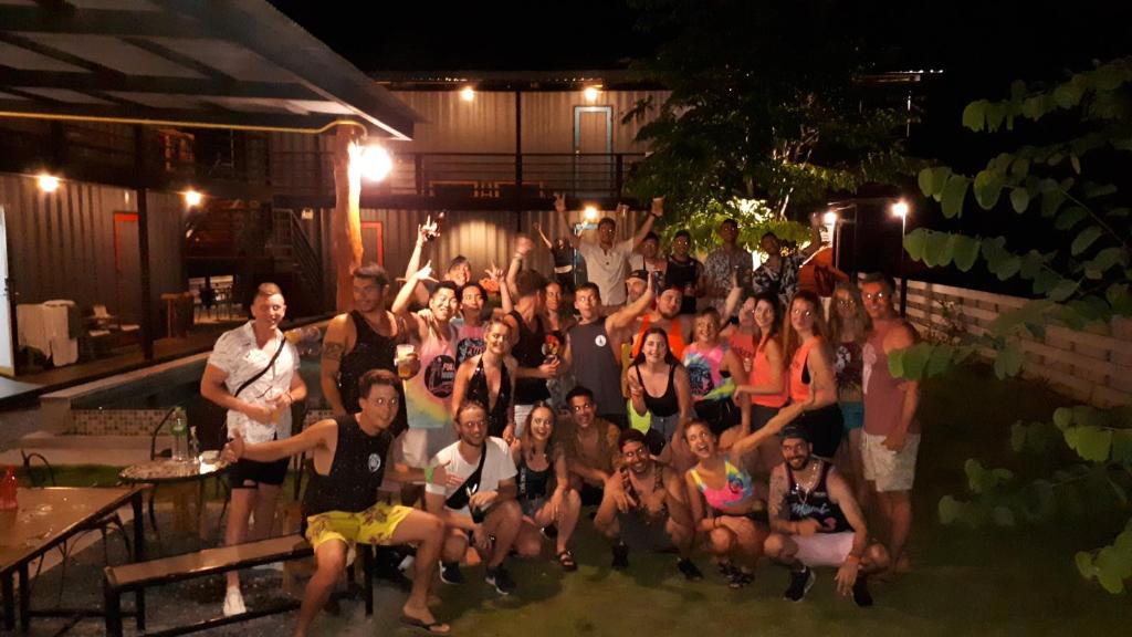 a group of people posing for a picture at night at Na-tub Hostel in Baan Tai