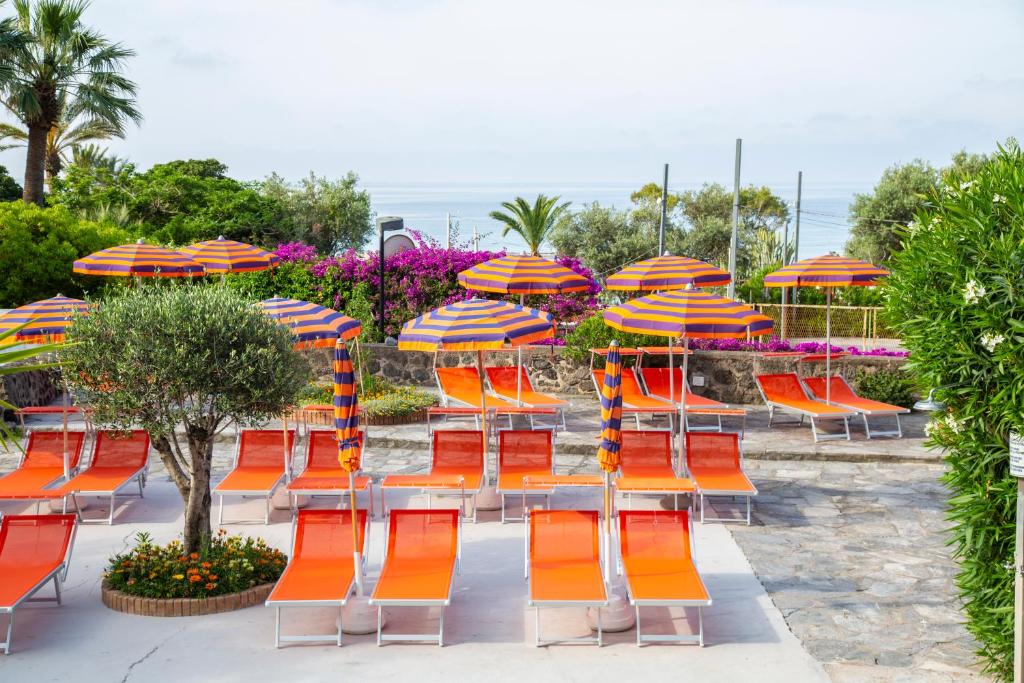 a group of orange chairs and umbrellas at Hotel La Mandorla in Ischia