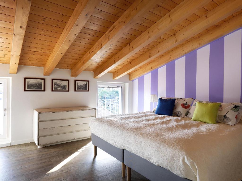 a bedroom with a bed with purple and white stripes at La Mia Dolce Vita in Calvagese della Riviera