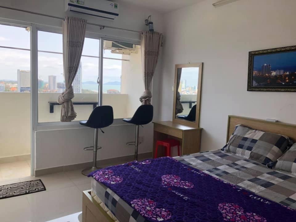 um quarto com uma cama, 2 cadeiras e uma janela em Happy House em Vung Tau