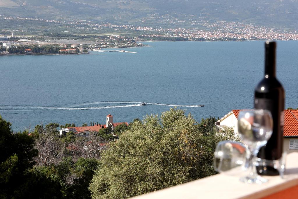 een fles wijn op een tafel met uitzicht op het water bij Bridgeview apartment in Trogir