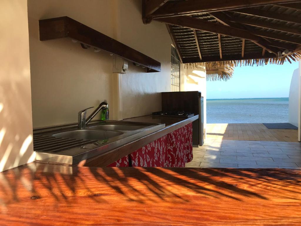 - une cuisine avec évier et vue sur l'océan dans l'établissement Ocean Breeze Bungalow, à Tevaitoa