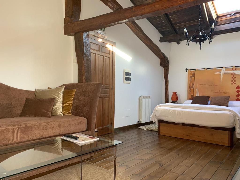 una camera da letto con un letto, un divano e un tavolo di Casa San Andres Del Valle a Estollo