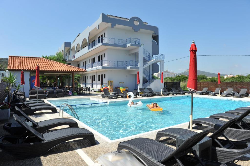 una piscina con sillas y cisnes en un hotel en Maritime, en Kremasti