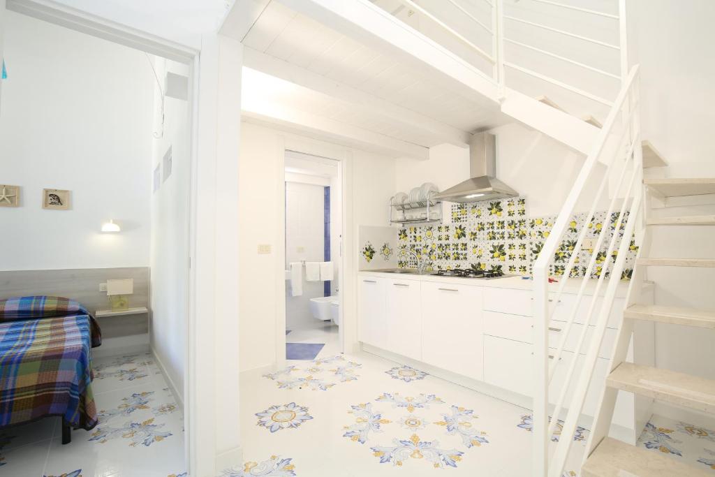 Biały pokój na poddaszu ze schodami i sypialnią w obiekcie Residence La Conchiglia w mieście Vieste
