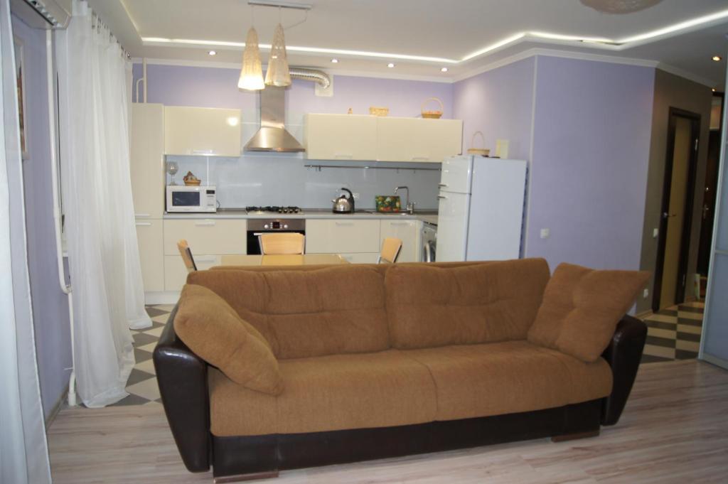 a living room with a couch and a kitchen at Apartment on Lunacharskogo in Tver