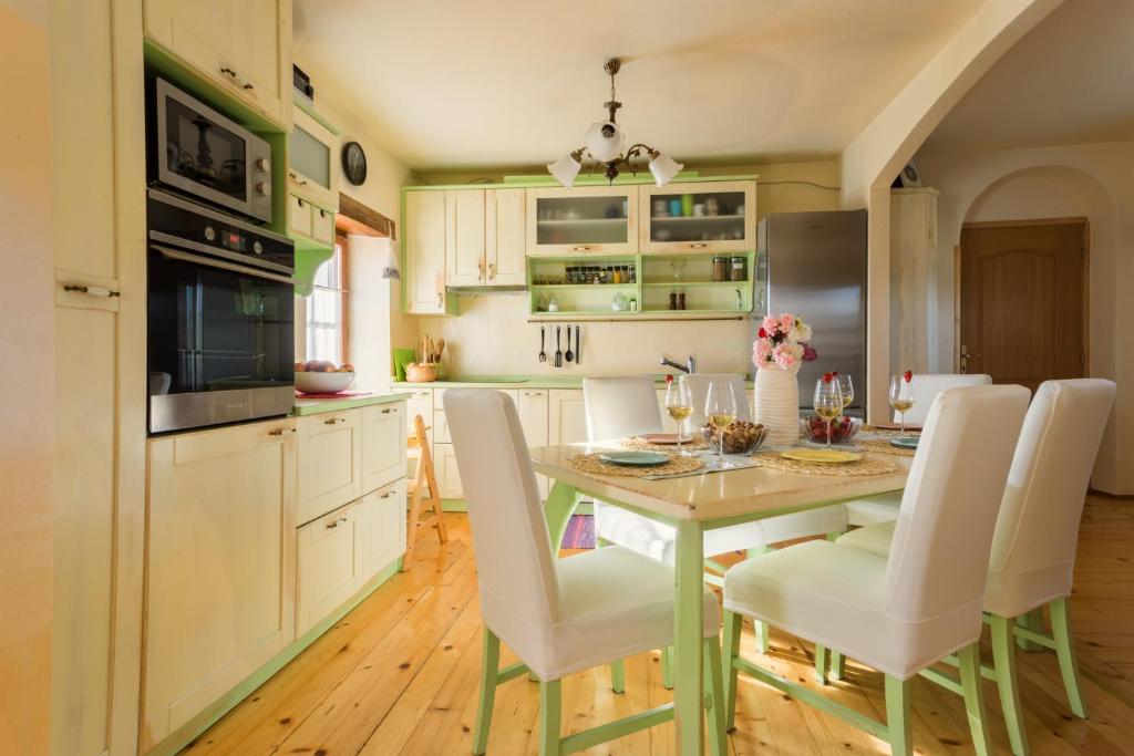a kitchen with a table and white chairs in it at Casa Romantica in Umag