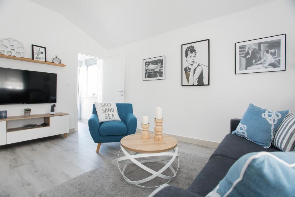 a living room with a blue couch and a table at Apartment Movie in Primošten