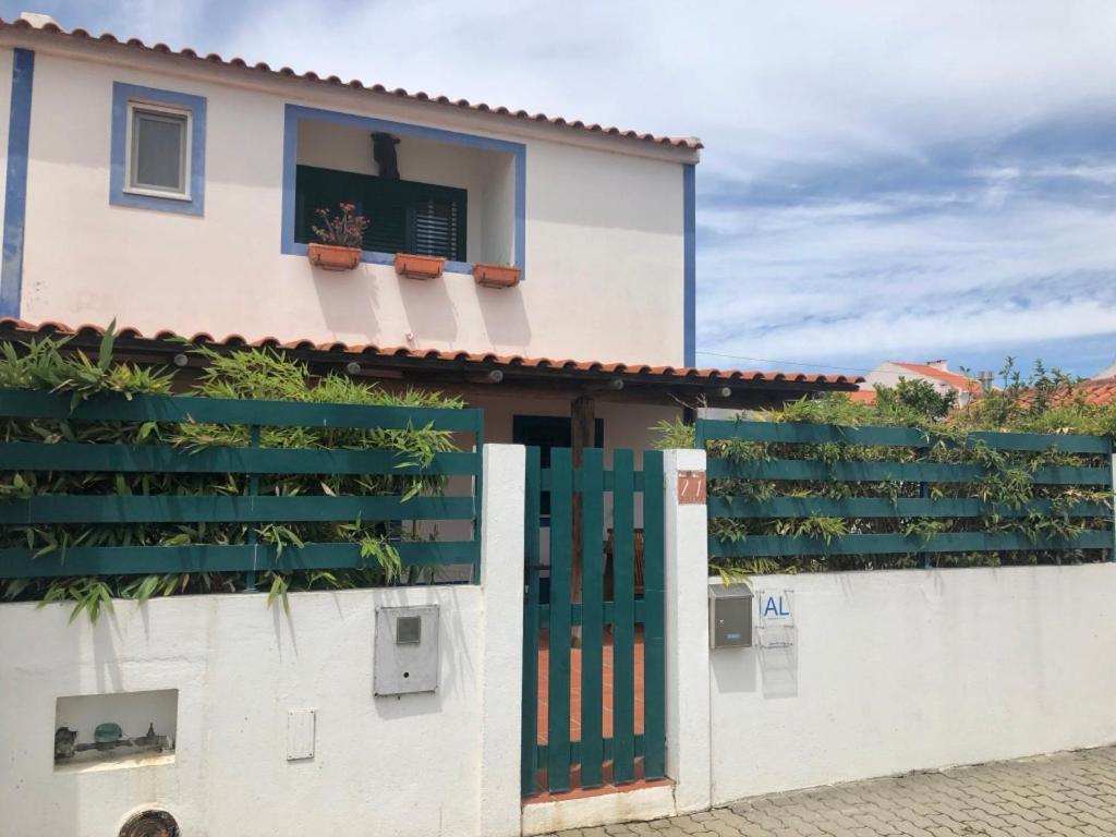 a house with a green door and a white fence at Casa na Comporta in Comporta