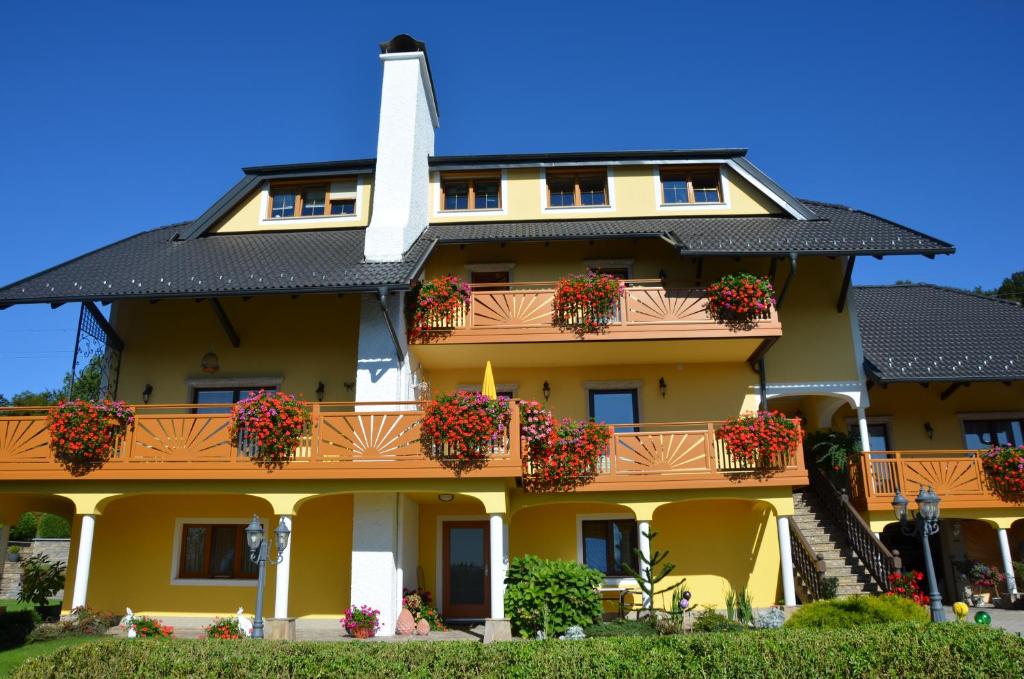 a yellow building with flower boxes on the balcony at Frühstückspension Porranzl in Persenbeug-Gottsdorf