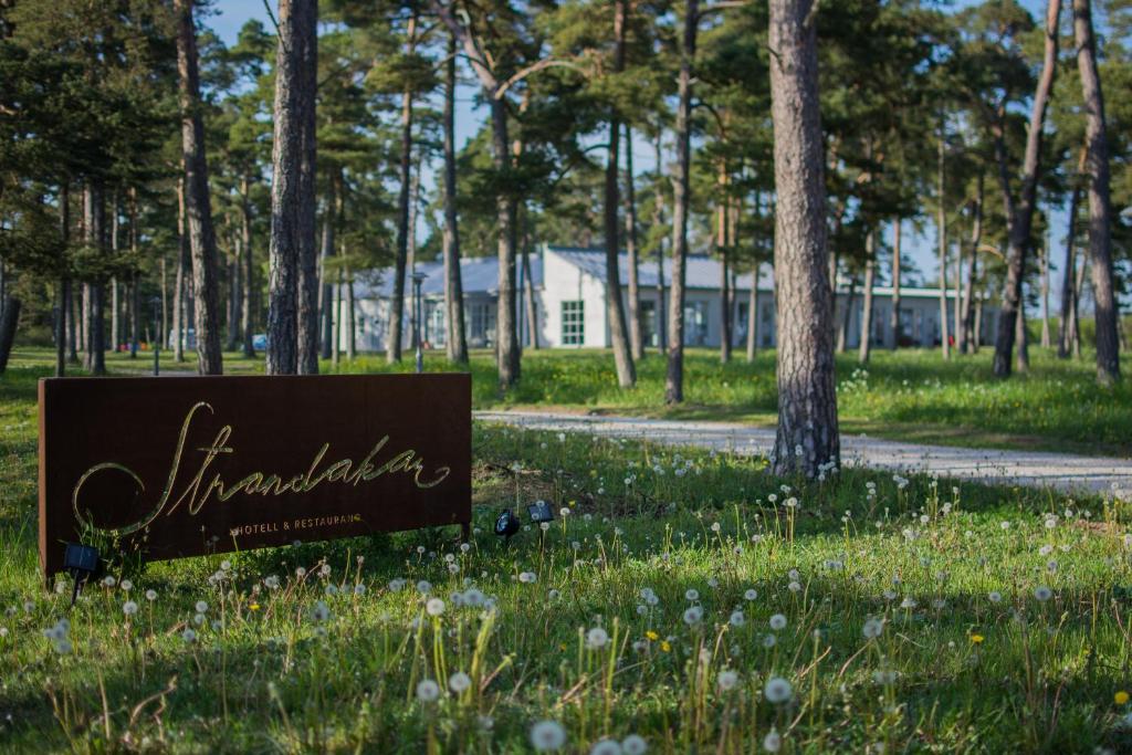 a sign in the grass next to a road at Strandakar Hotell & Restaurang in Stånga