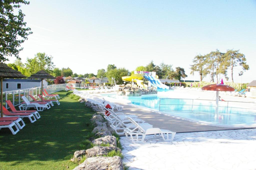 a large swimming pool with chairs and a slide at BARERO LOCATIONS DE MH PROCHE BEAUVAL ET CHATEAU DANS LOIRE et CHER in Onzain
