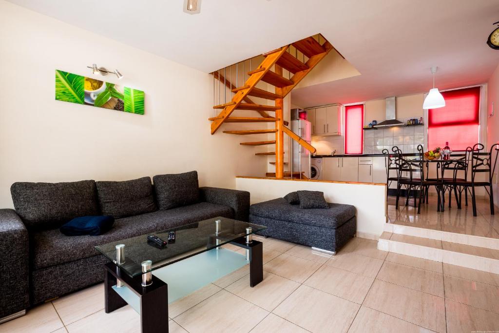 un soggiorno con divano e tavolo di Apartamentos El Cortijo a Playa de las Americas