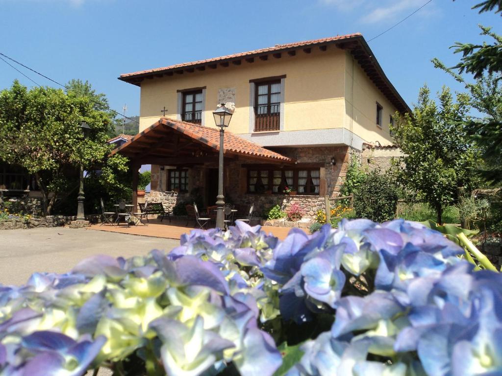 a pile of purple flowers in front of a building at Hotel Rural La Casona del Fraile in Colunga