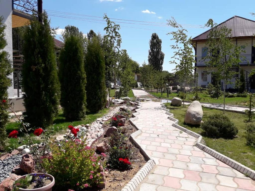einen Garten mit Blumen und einem Steinweg in der Unterkunft Пансионат "Скиф-Мурок" in Bosteri
