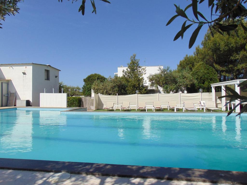 a large swimming pool with chairs in front of a building at Raggio Di Sole in Alberobello